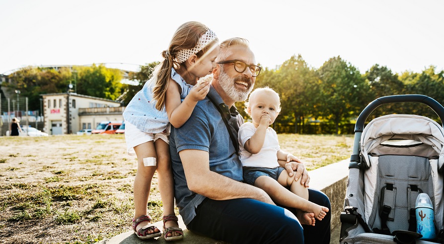 Smiling man sitting with two children