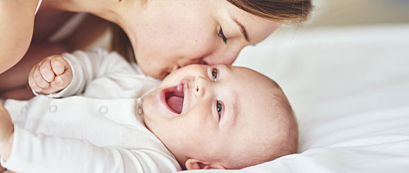 mom kissing infant