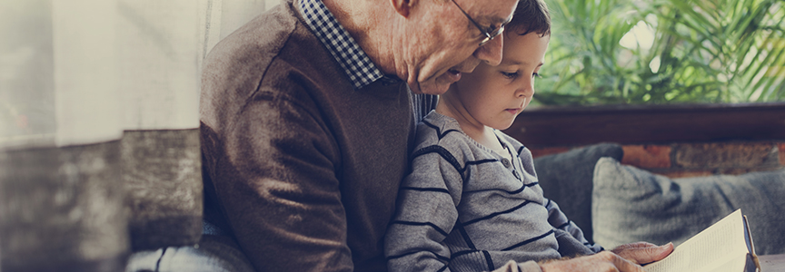 Grandfather reading book with grand child