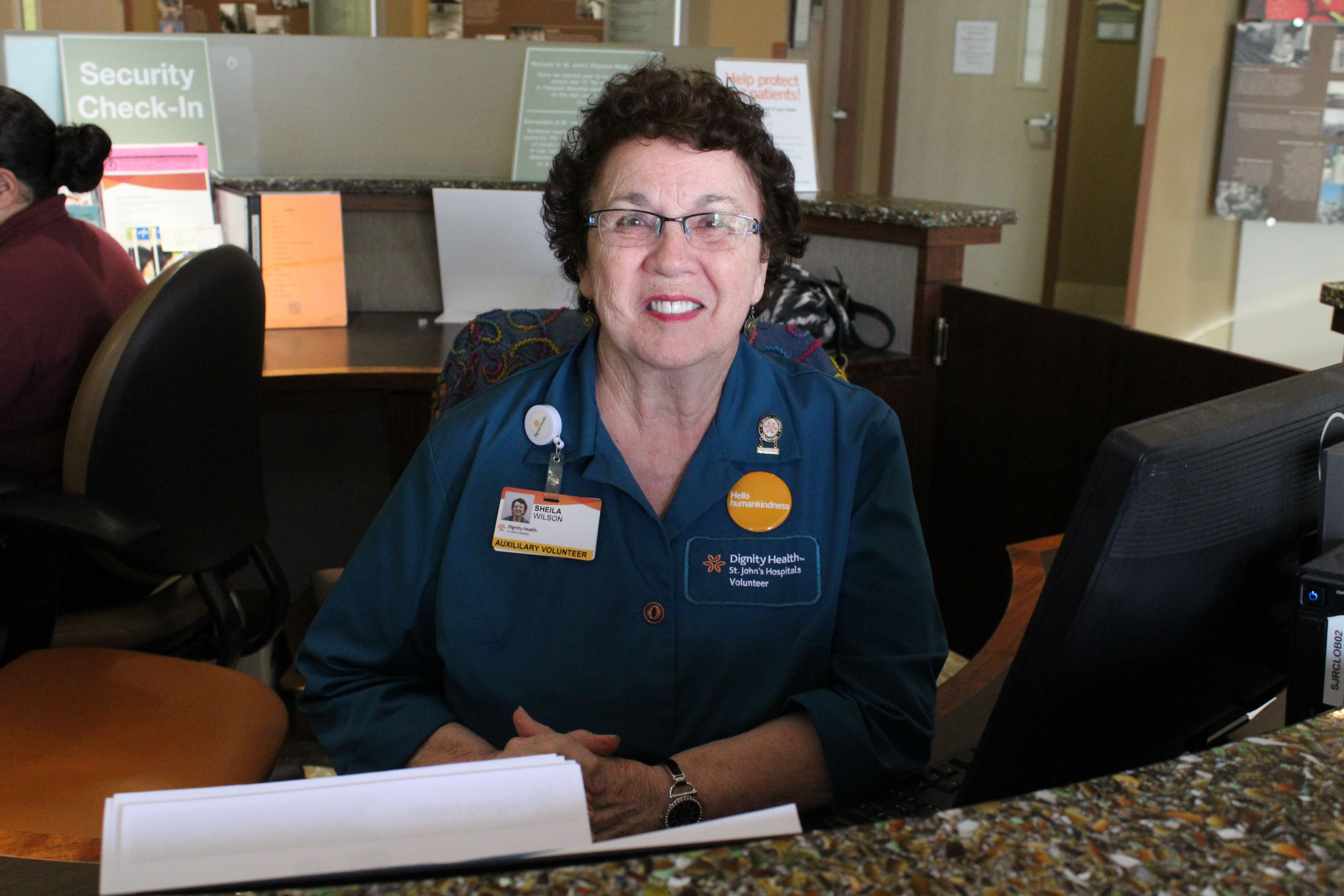 volunteer at desk looking at camera